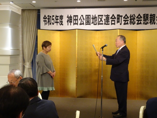 小松前連合婦人部長への感謝状を読み上げる中曽根連合町会長